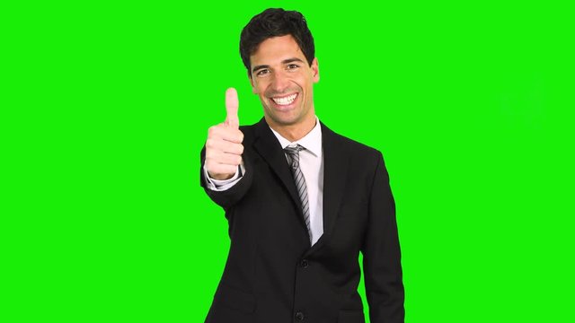 Smiling young man showing thumbs up, green screen chroma key