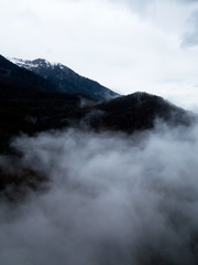 Aerial view of fog, clouds over the trees and mountains of the Caucasus, Sochi area, Krasnaya Polyana, Gorki Gorod.