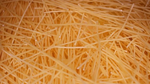Vermicelli angel hair soup pasta closeup texture video on rolling rotating looping plate