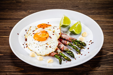 Fried egg with asparagus on white background