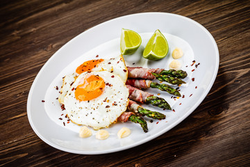 Fried egg with asparagus on white background