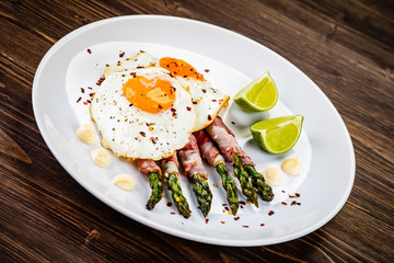 Fried egg with asparagus on white background