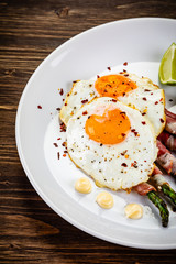 Fried egg with asparagus on white background
