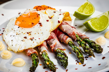 Fried egg with asparagus on white background