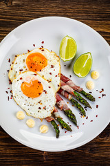 Fried egg with asparagus on white background