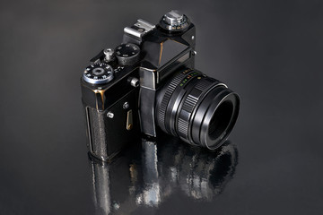 old Soviet retro film camera on a gray background with reflection