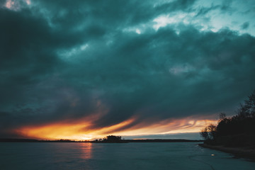 Fototapeta na wymiar A picturesque sunset over a frozen lake.