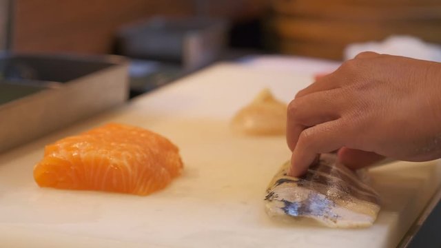 Japanese chef use sharp knife slicing fresh fish for sashimi.  Squid, Salmon, Hotate