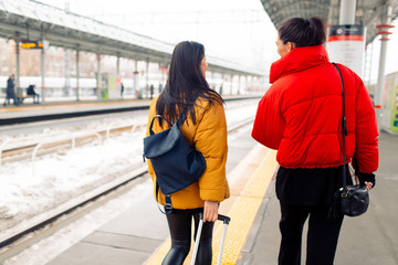 Young females in down jacket take  the train.