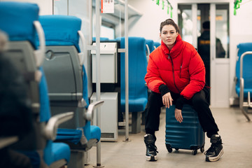 Young female sitting her baggage in railway train.