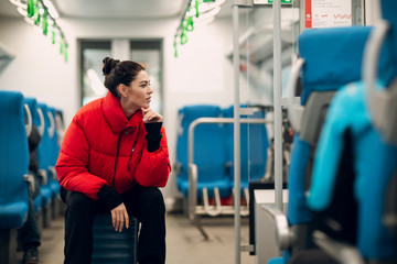 Young female sitting her baggage in railway train.
