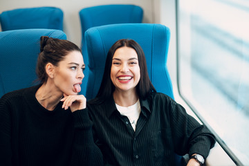 Two girlfriends going to trip by railway train.  Women Friendship Concept.