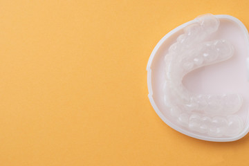 Plastic cap for teeth in a white case, closeup