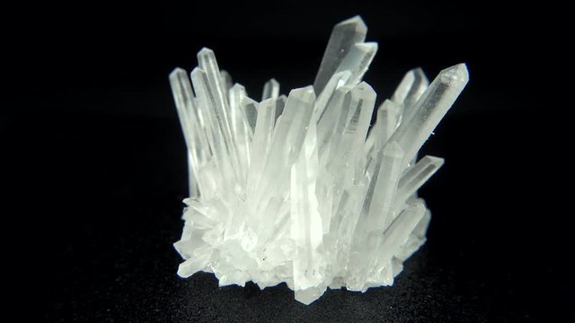 Seamlessly rotating a white mineral (Quartz) in front of black background