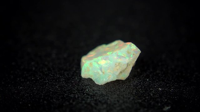 Seamlessly rotating a colorful mineral (Opal) in front of black background