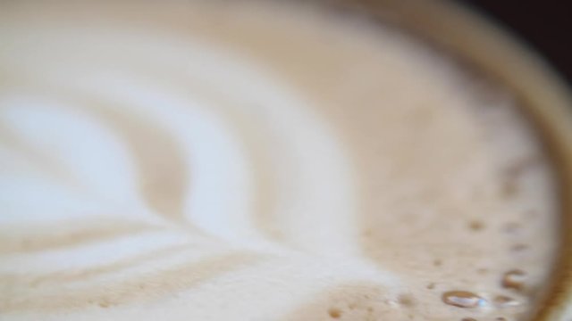 A panning macro shot of a latte art, the detail shows the bubbles and beautiful design in the foam so very clearly 