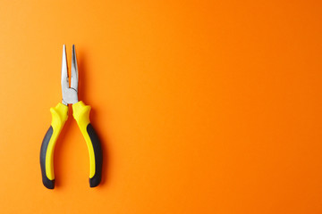 Pliers on orange background