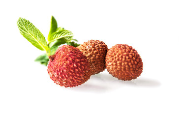 Three lychees and a sprig of mint isolated on white