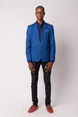 Full body shot of young bald African businessman in suit