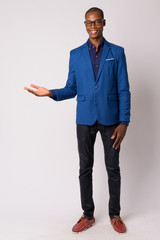 Full body shot of young happy bald African businessman smiling while showing something