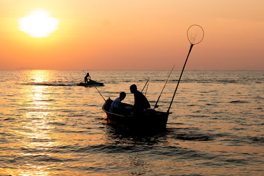 2 fisherman on the boat  in the sea is fishing when sunset in pattay