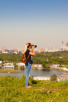 Woman traveler photographer take a photo of the city from the point of view