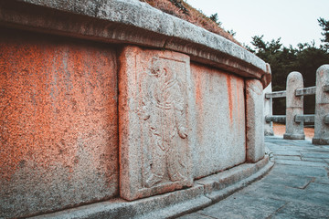Relief carvings of Oriental zodiac god, half man, half animal, standing guard around the tomb of General Kim Yusin in Gyeongju, South Korea. Known as the Hero of the Silla Kingdom