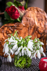 Snowdrops bouquet on table with other flowers in the background