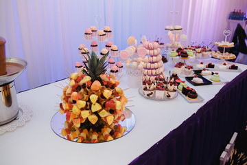 Candy bar decorated with fruit, green background.