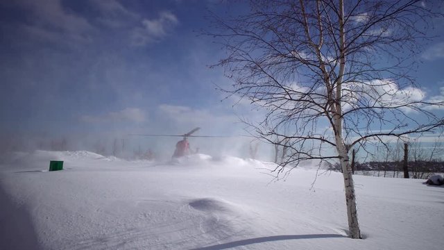 Landing civil helicopter MI-2 on the snow-covered helipad clear day in the park. The sound of the engine and propellers.