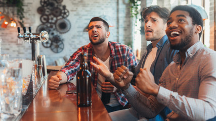 Football in pub. Friends watching match in sport bar