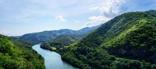 Beautiful  panorama: Top view blue river in green  mountains valley. Travel, tourism, wanderlust concept. Text space