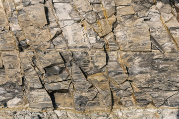 Texture of dark gray slate or background for design..The surface of the rock is a surface with a wave pattern.