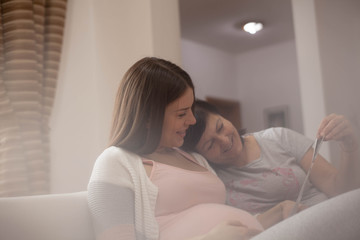 Mother supporting her pregnant daughter .