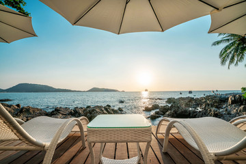 Sun bed at the beach with beautiful golden lighting sunset in the ocean
