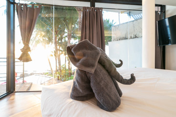 Interior design in bedroom of pool villa with  elephant towel ,golden lighting sunset