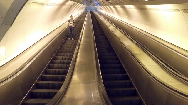 Man on escalator in an empty subway