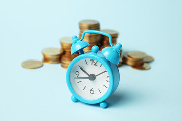 Fototapeta na wymiar Alarm clock and golden money coins, capitalization. Time is money concept, payment.