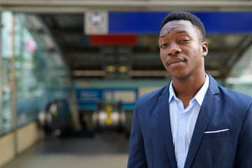 Fototapeta premium Young handsome African businessman outside the subway train station