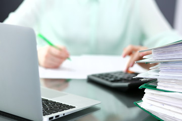 Bookkeeper or financial inspector  making report, calculating or checking balance. Audit and tax service concept. Green colored image background 