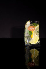 Mojito cocktail at the bar. Mojito cocktail over black background. Cocktail Mojito in the nightclub. Ice cold Mojito.