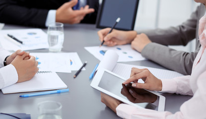 Woman hands using tablet at meeting. Business people group working together in office, close-up. Negotiation and communication concept