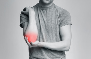 Cropped young man suffering from painful elbow