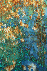 Rusty metal wall, old iron sheet, covered with rust with multi-colored paint. Trace of remnant of old paint in large deep crack on texture of surface rusty metal. Background texture old paint on metal