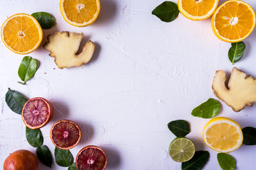 Flat lay the raw fresh citrus fruit - yellow and red orange fruit , ginger and lime leaves.