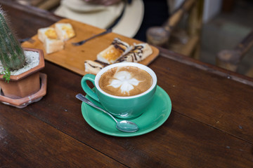 Hot latte art coffee on wooden table