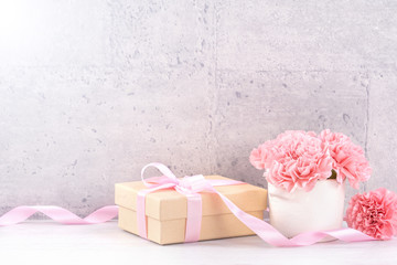 May mothers day handmade giftbox wishes photography - Beautiful blooming carnations with pink ribbon box isolated on fair-faced gray background desk, close up, copy space, mock up