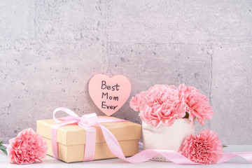 May mothers day handmade giftbox wishes photography - Beautiful blooming carnations with pink ribbon box isolated on fair-faced gray background desk, close up, copy space, mock up