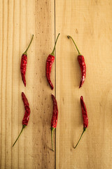 6 dried red raw hot chili cayenne pepper sorted on a wooden plate. Spicy food. Top view, flat