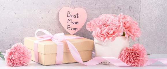 May mothers day handmade giftbox wishes photography - Beautiful blooming carnations with pink ribbon box isolated on fair-faced gray background desk, close up, copy space, mock up